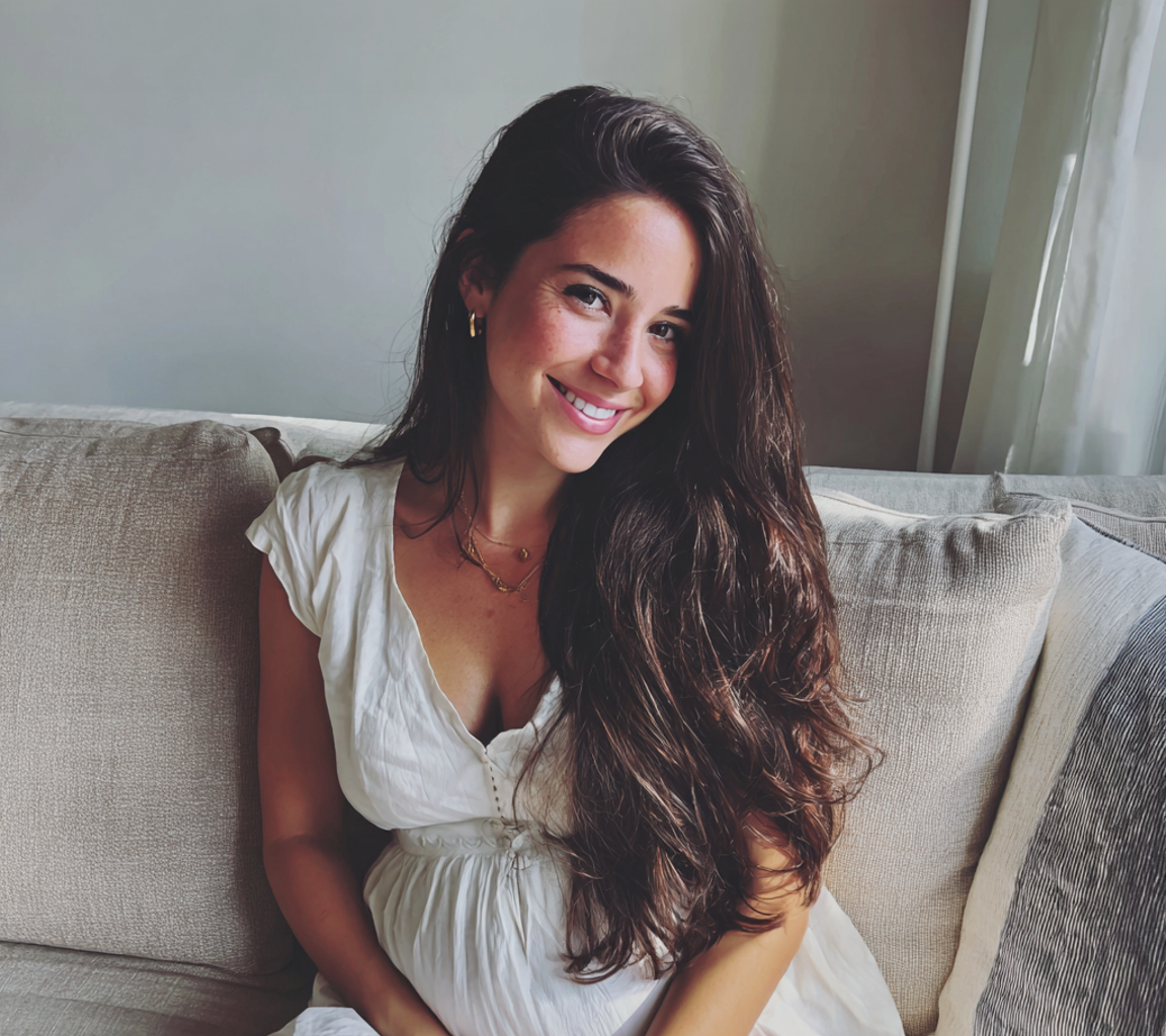 A smiling pregnant woman wearing a white dress | Source: Midjourney