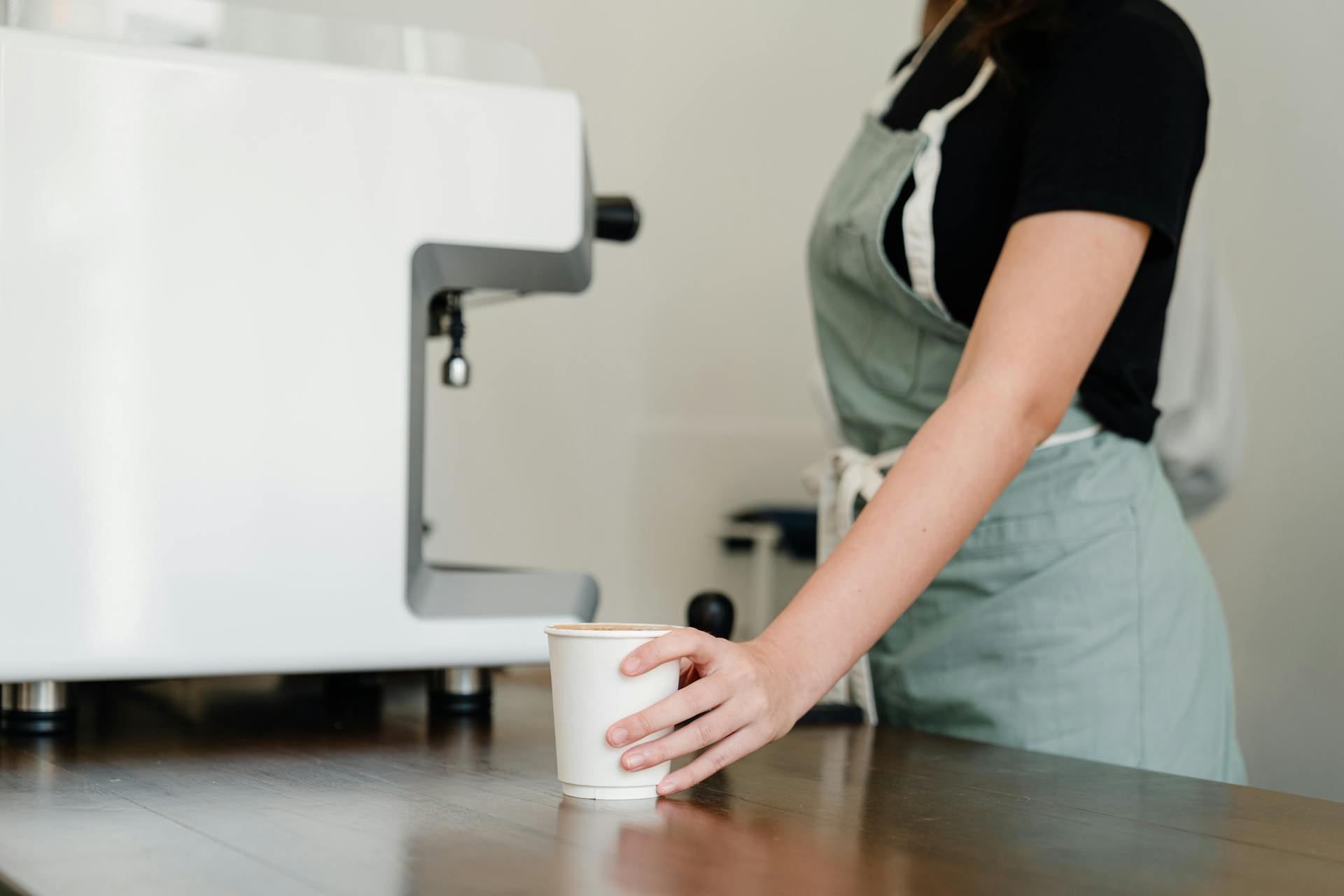 A waitress standing near a coffee machine | Source: Pexels